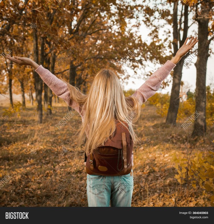 Блондинка спиной в лесу осенью