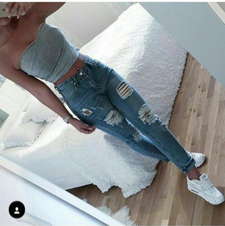 Девушка в рваных джинсах со спины