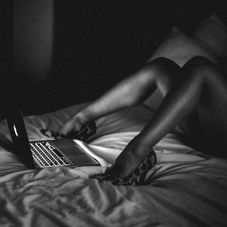 Девушка с ноутбуком на кровати