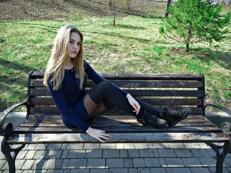 Блондинка на скамейке в платье