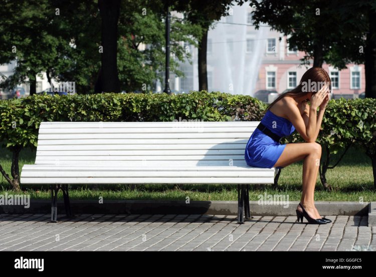 Грустная женщина на скамейке