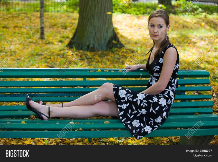 Девушка на скамейке поджав ноги