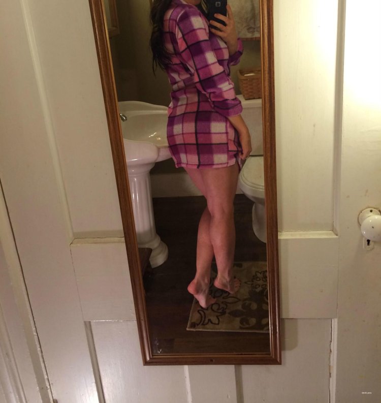 Брюнетка в халате перед зеркалом