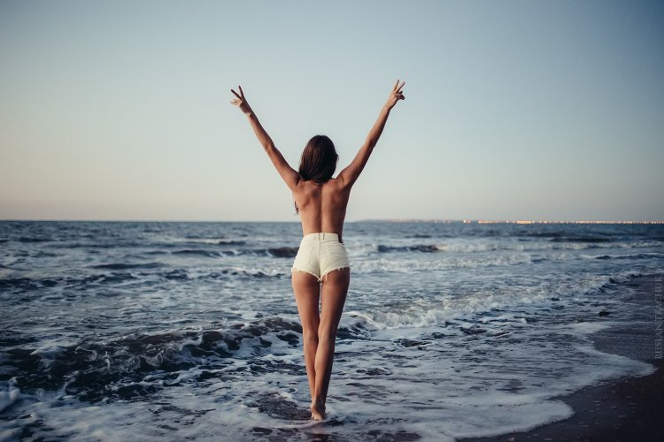 Девушка в купальнике с поднятыми руками