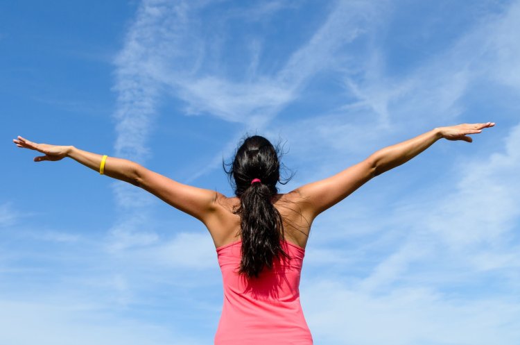 Девушка с поднятами руками с зади