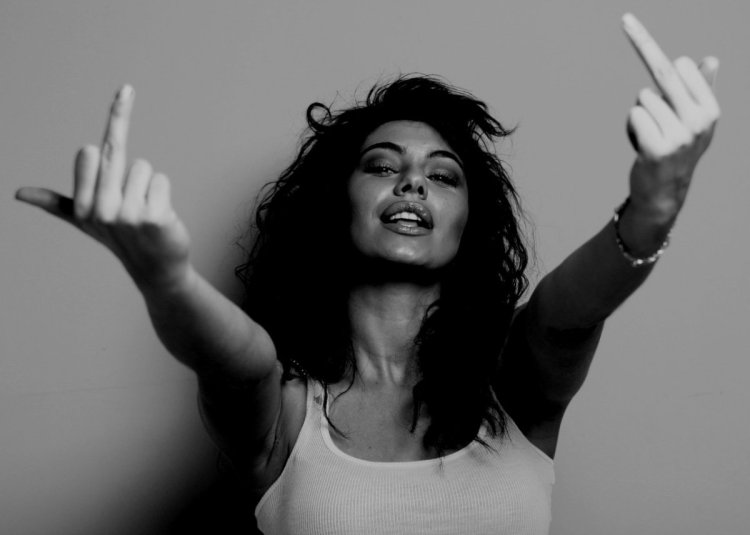 Девушка в белой кофте показывает фак