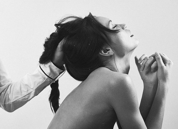 Мужчина держит девушку за волосы