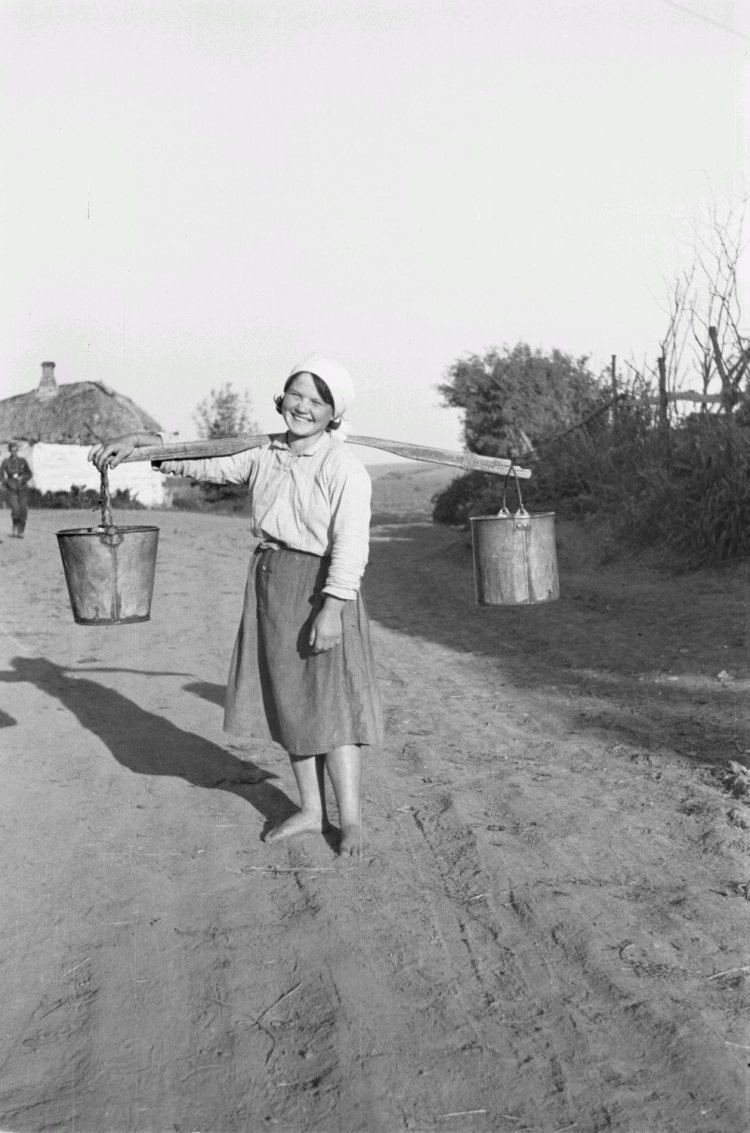 Несет воду в коромысле