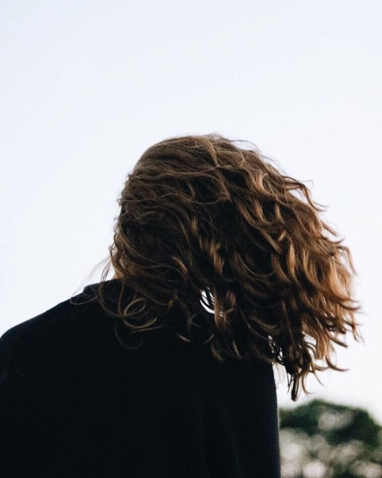 Девушка с кучерявыми волосами со спины