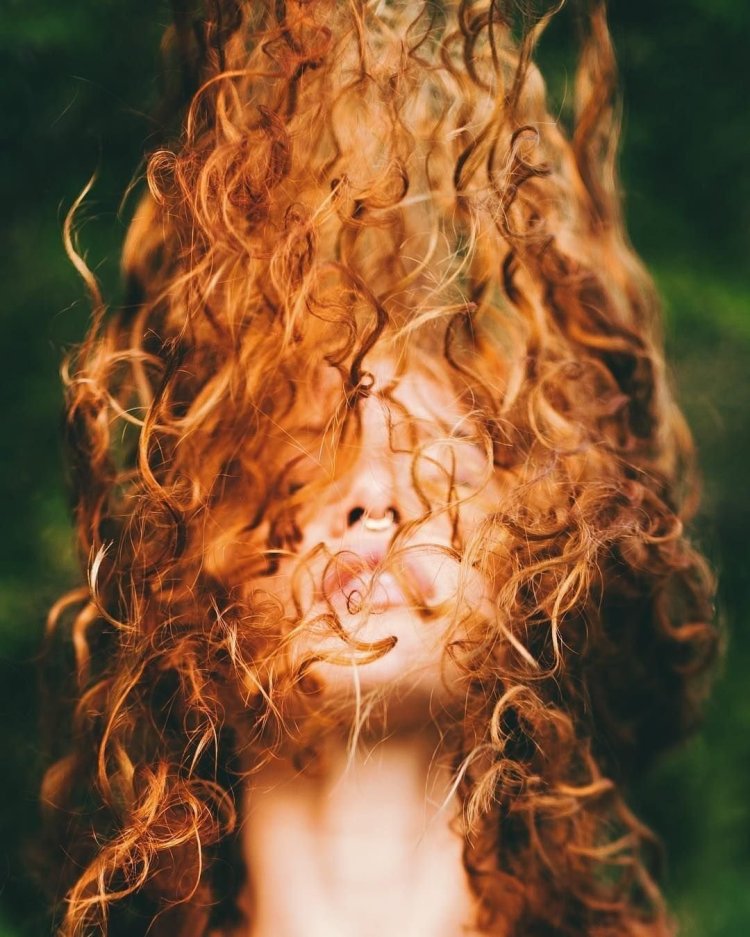 Девушка с кудрявыми волосами на море спиной