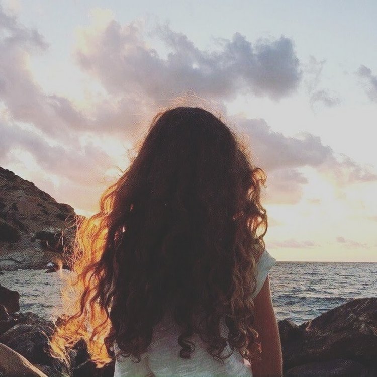 Кудрявая девушка на море