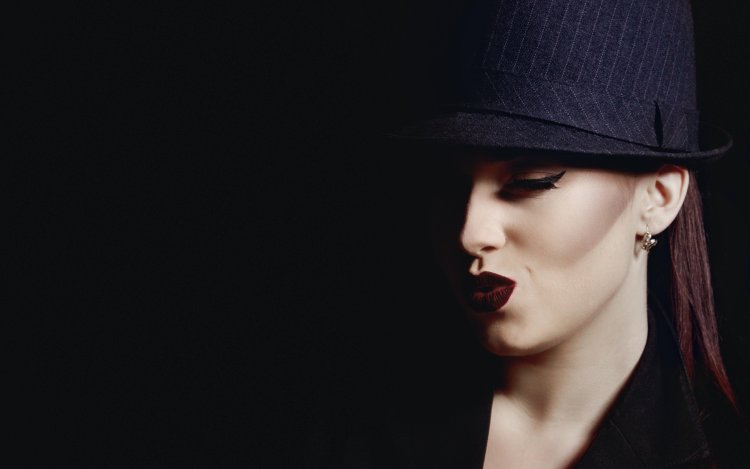 Девушка в шляпе на темном фоне