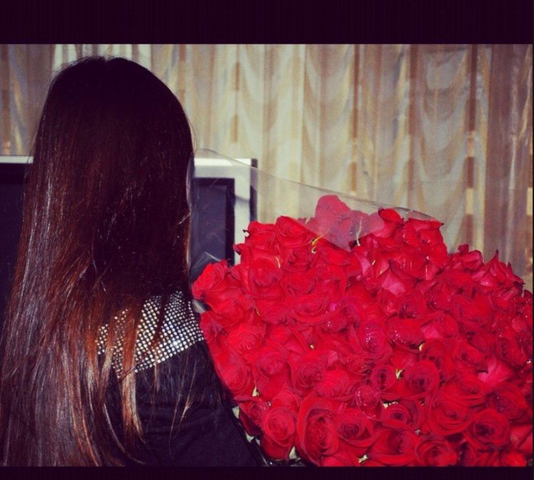 Брюнетка с букетом цветов без лица