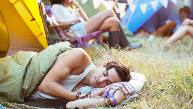 Мужчина спит в палатке