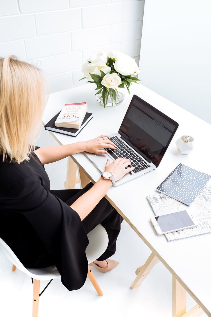 Девушка за ноутбуком в офисе