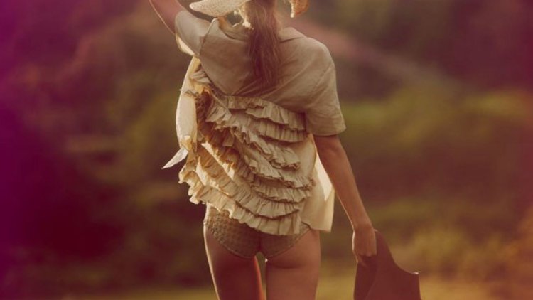 Девушка в шляпе стоит спиной