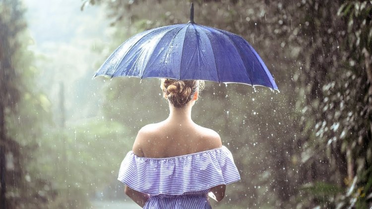 Девушка с зонтом под дождем летом