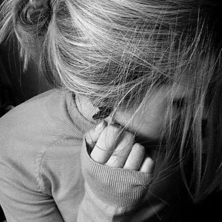 Девушка блондинка закрывает лицо руками