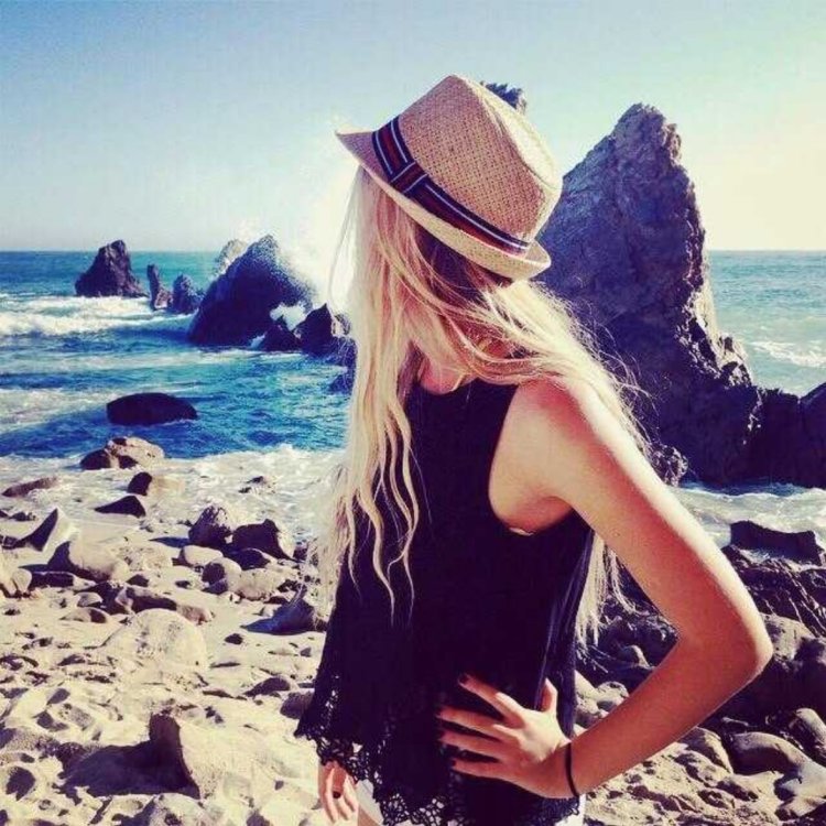 Девушка блондинка в шляпе на море