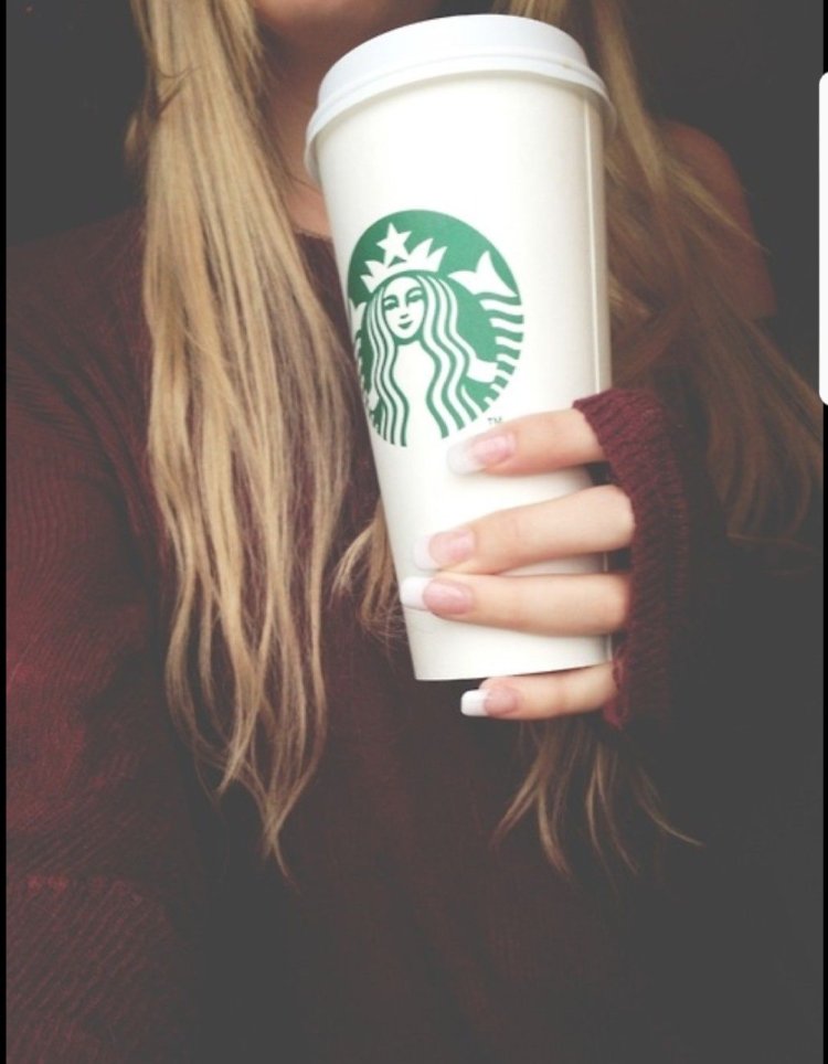 Стакан кофе в руке девушки