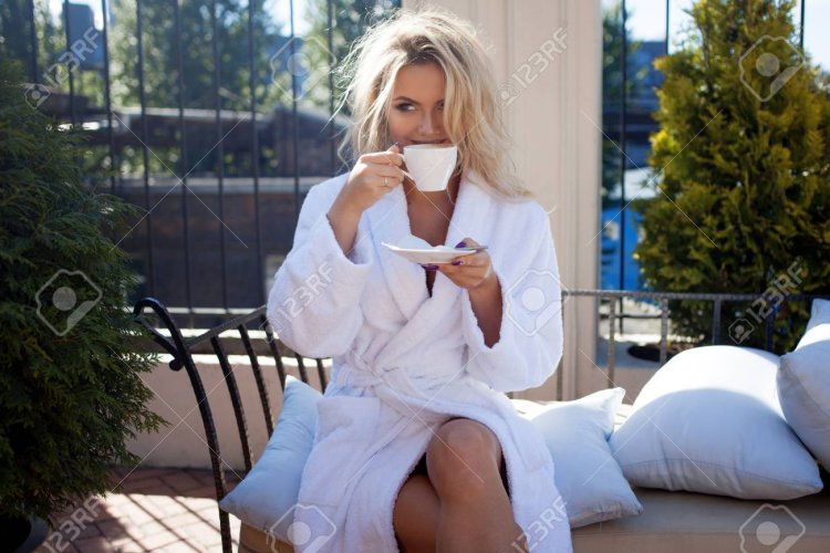 Девушка в халате пьет кофе