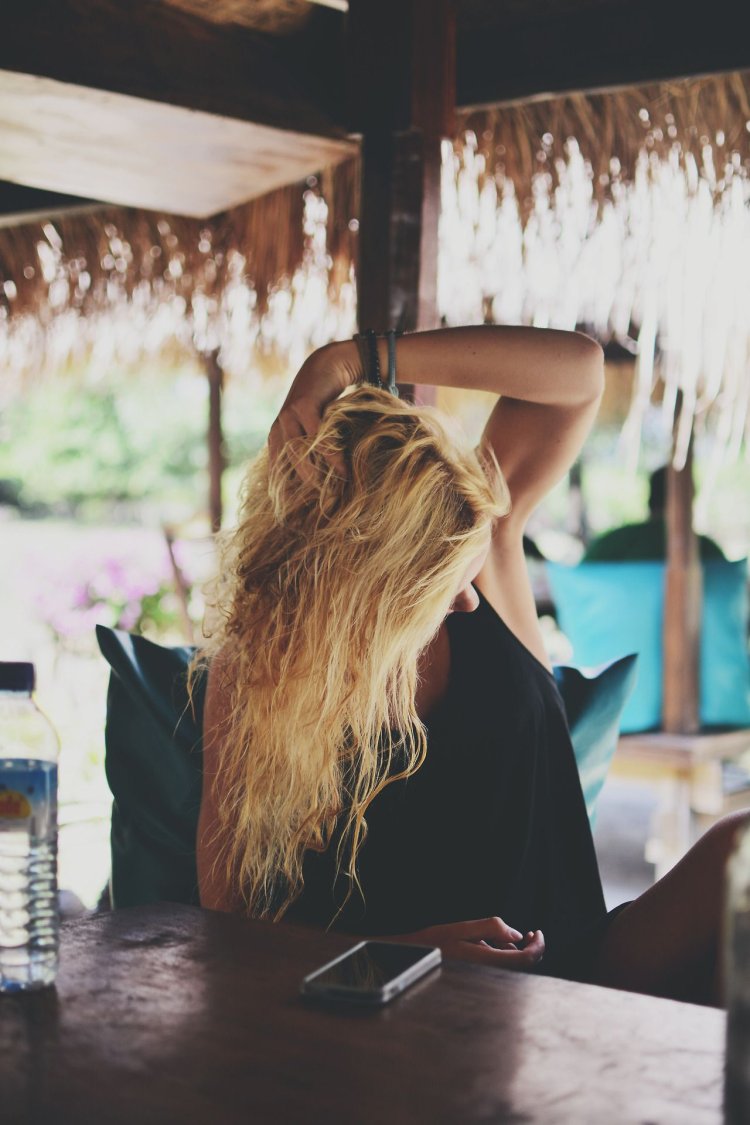 Девушка блондинка в кафе со спины