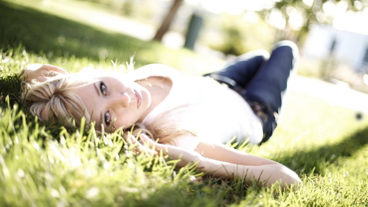 Девушка блондинка лежит на траве