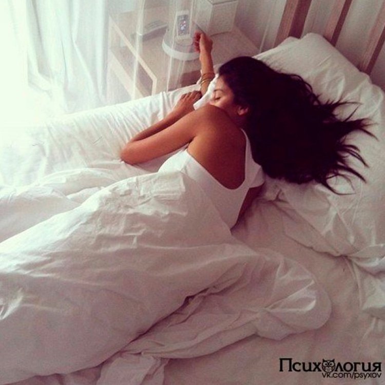 Брюнетка в постели спиной