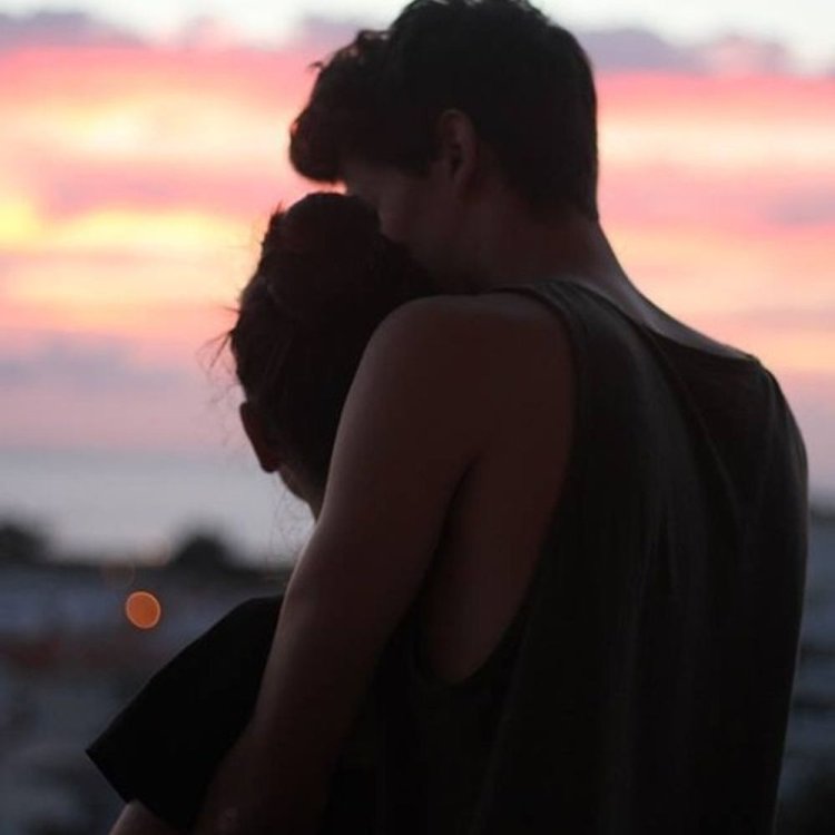 Обнимает девушку сзади