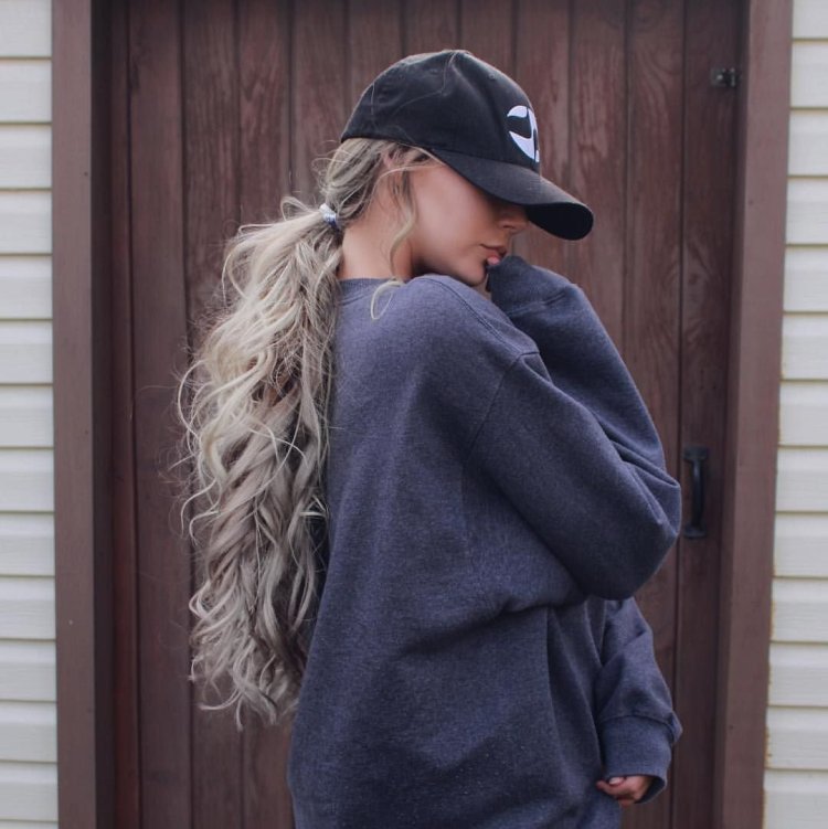 Блондинка в бейсболке с длинными волосами