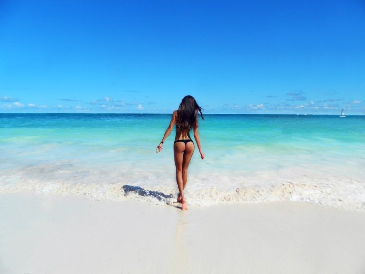 Брюнетка на море со спины