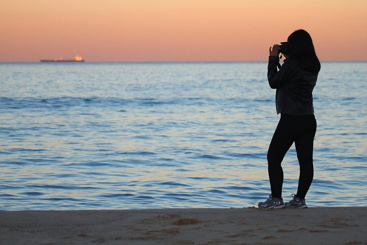 Женщина на берегу моря со спины