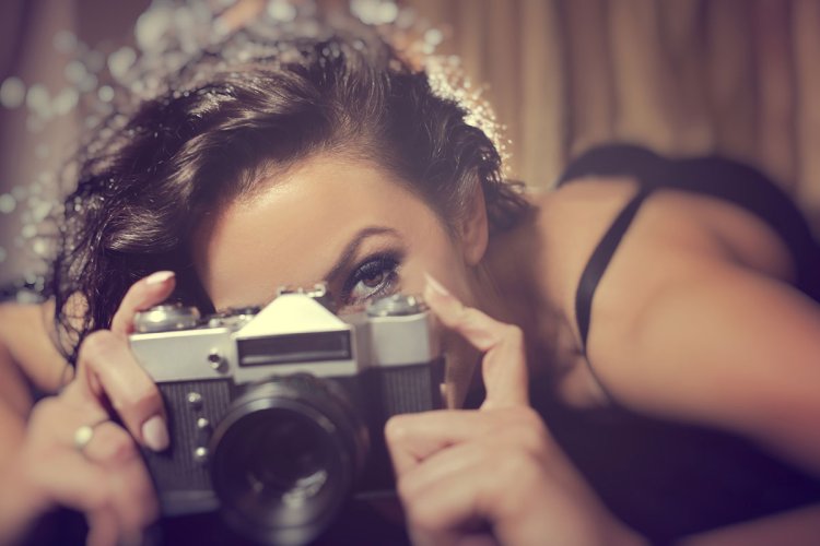 Кудрявая девушка с фотоаппаратом