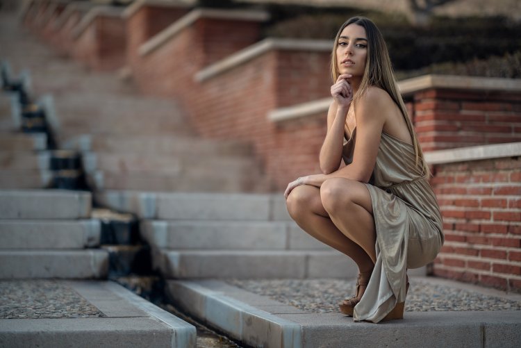 Девушка в платье на коленях сидит