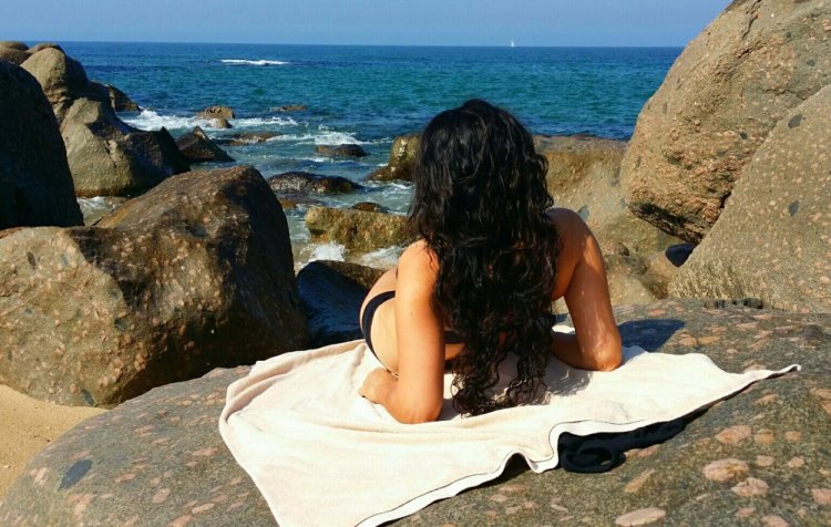 Кудрявая девушка со спины на море