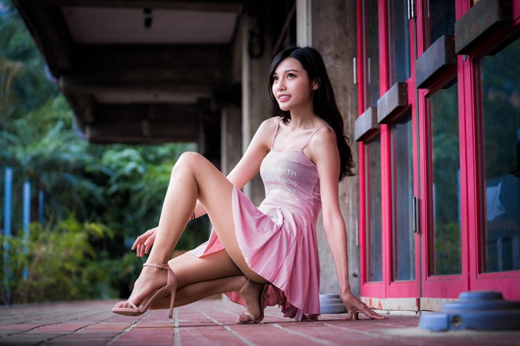 Азиатка сидит на корточках