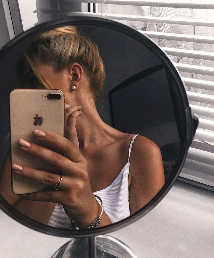 Девушка с айфоном в зеркале