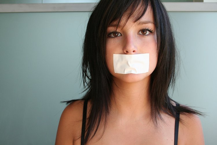 Девушка с заклеенным ртом скотчем