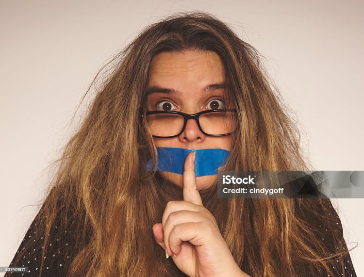 Девушка с заклеенным ртом в очках