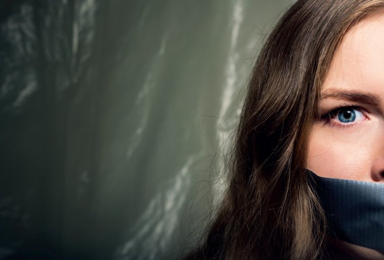 Красивая девушка с завязанным ртом