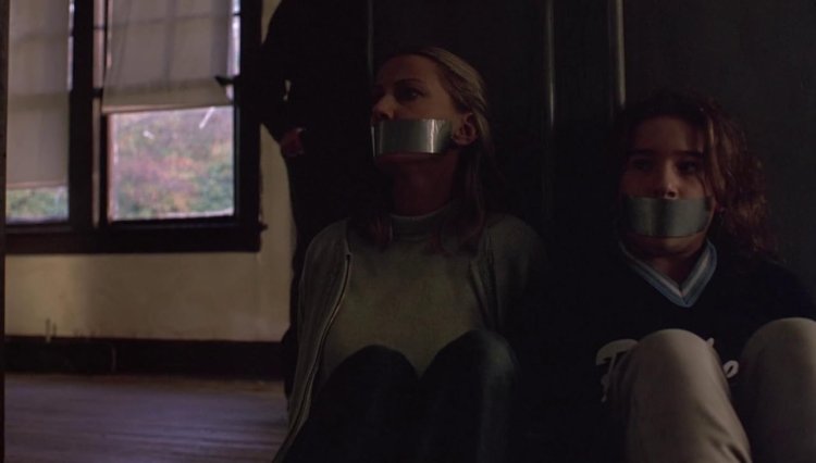 Девушка с заклеенным ртом и связанная