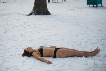 Девушка лежит на снегу