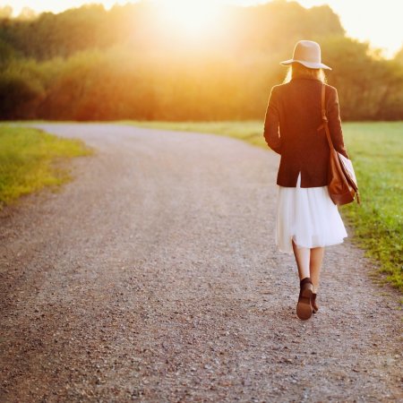 Женщина идет по дороге