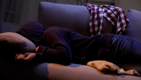 Мужчина лежит на диване без лица