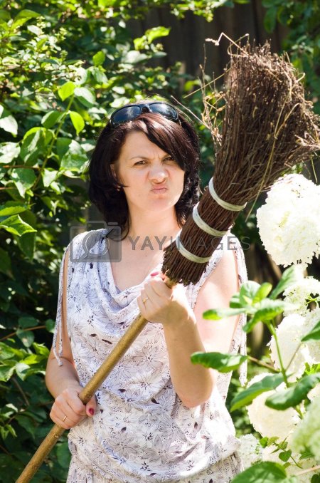 Женщина подметает веником