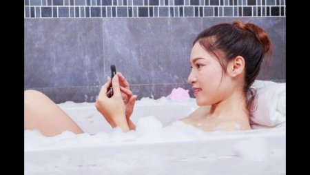 Девушка в ванне с телефоном