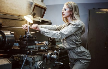 Женщина у станка на заводе