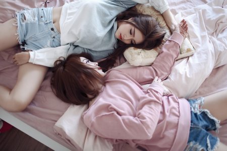 Две девушки лежат на кровати