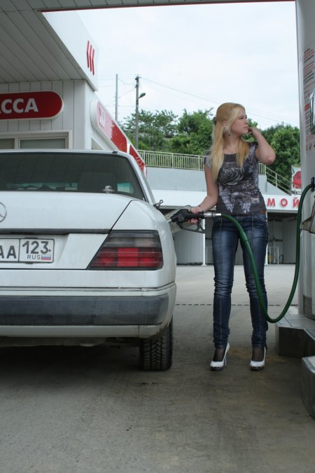 Девушка заправляет автомобиль