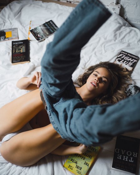 Девушка в джинсах на кровати